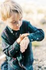 A five year old boy playing with insects by the lake — Stock Photo