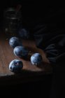 Blaue Pflaume auf einem Holztisch vor dem Hintergrund eines Glasgefäßes — Stockfoto