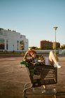 Herencia mixta asiático-español joven hembra posando con carrito de compras - foto de stock