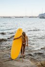 Young female surfer in bikini at the small bay in Moraira — Stock Photo