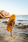 Joven surfista femenina en bikini en la pequeña bahía de Moraira - foto de stock
