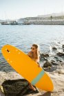 Joven surfista femenina en bikini en la pequeña bahía de Moraira - foto de stock