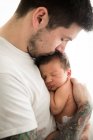 Padre tenendo il figlio sullo sfondo beige — Foto stock