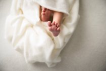 Detailaufnahme, neugeborenes Baby Fuß, in weiße Decke gewickelt — Stockfoto
