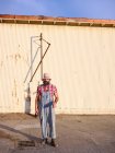 A man dressed in alternative fashions stands in an industrial setting. — Stock Photo