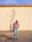 Ein alternativ gekleideter Mann steht in einem industriellen Umfeld. — Stockfoto