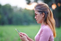 Une femme utilise le téléphone portable en plein air — Photo de stock