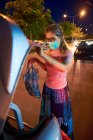 Женщина положила ее принадлежность к багажнику автомобиля после покупки во время COVID — стоковое фото