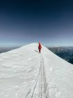 Pessoas andando montanha abaixo com neve nas montanhas — Fotografia de Stock