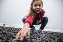 Jeune fille cherche à sauter des pierres — Photo de stock
