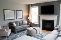 Интерьер современной гостиной с диваном и камином — стоковое фото