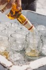 Versando whisky in bicchieri con ghiaccio — Foto stock