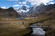 One person hiking towards the tents of a camp in Cordillera Huayhuash — Stock Photo