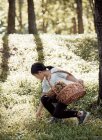Маленька дівчинка в окулярах і квітах на фоні лісу — стокове фото