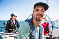 Man smiling during a family sail on sunny summer day — Stock Photo