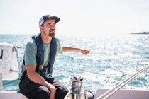 Людина в капелюсі на човні в морі — стокове фото