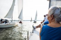 Middle aged Woman enjoying summer sail race during golden hour — Stock Photo