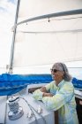 Donna di mezza età godendo vela estiva durante l'ora d'oro — Foto stock