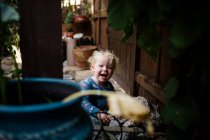 Blonde garçon de deux ans souriant et riant sur le patio avant — Photo de stock