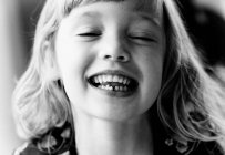 Portrait of a young girl showing her wobbly tooth smiling — Stock Photo