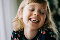 Junges Mädchen mit einem wackeligen Zahn, das lächelnd seine Zähne zeigt — Stockfoto