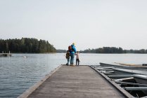 Батько і його діти щасливо рибалять на кінці пірсу разом — стокове фото