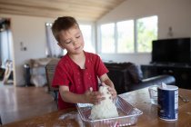 Мальчик строит глиняный вулкан в домашней школе — стоковое фото