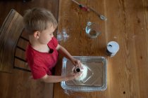 Overhead view of boy building clay volcano — Stock Photo