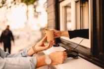 Zugeschnittenes Bild eines Kunden, der mit Kreditkarte bezahlt und Kaffee im Café kauft — Stockfoto