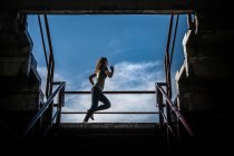 Jovem mulher em um terno nas escadas — Fotografia de Stock
