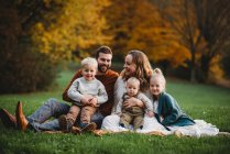 Красива сім'я в парку посміхається в осінній день — стокове фото