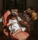 Retrato de menina sentada na cadeira — Fotografia de Stock