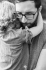 Black and white close up of a millennial father comforting daughter — Stock Photo