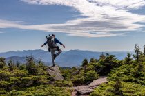 Hiker with backpack standing on top of mountain in background — Stock Photo