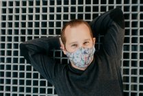 Розслаблений чоловік на вулиці в масці для обличчя — стокове фото