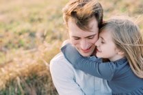 A happy and loving five year old girl holding on to her father — Stock Photo