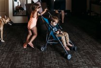 Young siblings playing in stroller in hotel room in Palm Springs — Stock Photo