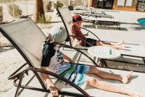 Close up view of young brothers in pool chairs laughing together — Stock Photo