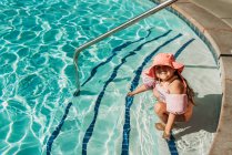 Молодая девочка дошкольного возраста плавает в бассейне на отдыхе в Палм-Спрингс — стоковое фото