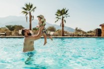 Pai brincando com seu filho na piscina — Fotografia de Stock