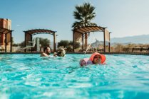 Young preschool age girl swimming in pool on vacation in Palm Springs — Stock Photo
