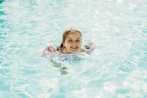 Молодая девочка дошкольного возраста плавает в бассейне на отдыхе в Палм-Спрингс — стоковое фото