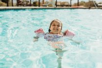 Lifestyle-Porträt eines jungen Mädchens, das im Urlaub im Hotelpool schwimmt — Stockfoto