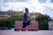 Человек тренирует ноги с силовыми выпадами в парке на открытом воздухе — стоковое фото