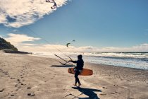 Un surfeur de cerf-volant se promène le long d'une plage en Californie du Sud, San Diego — Photo de stock