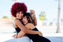 Zwei lateinamerikanische Frauen mit Afro-Haaren umarmen sich — Stockfoto