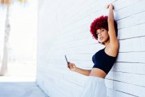 Donna con capelli afro rossi ascoltare musica con le cuffie — Foto stock