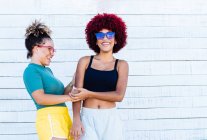 Две латиноамериканки с афро-волосами смеются — стоковое фото