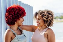 Дві латинські жінки з афро волоссям розмовляють — стокове фото