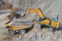 Carregadores carregando caminhões de mineração em poço aberto — Fotografia de Stock